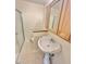 Bathroom showcasing a white pedestal sink, wooden vanity, and glass-enclosed shower at 2001 S Ashland Dr, Burlington, NC 27217