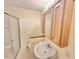 Bathroom featuring a white pedestal sink, wooden vanity, and glass-enclosed shower at 2001 S Ashland Dr, Burlington, NC 27217