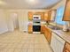 Traditional kitchen with natural wood cabinets and white appliances, offers a bright space at 2001 S Ashland Dr, Burlington, NC 27217