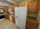 Traditional kitchen features neutral cabinets, tile floors and white refrigerator appliance at 2001 S Ashland Dr, Burlington, NC 27217