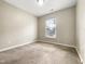 Sunlit bedroom with a large window, carpet floors, and neutral walls at 203 Canyon Lake Cir, Morrisville, NC 27560