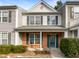 Charming two-story home with a brick facade and teal shutters, showcasing classic curb appeal in a townhome at 203 Canyon Lake Cir, Morrisville, NC 27560
