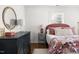 Bright bedroom features hardwood floors, a round mirror, a patterned bedspread, and bright natural light at 204 E Murray Ave, Durham, NC 27704