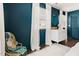 Stylish bedroom with dark blue walls, white curtains, and a decorative woven chair at 204 E Murray Ave, Durham, NC 27704