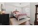 Cozy bedroom with hardwood floors, a patterned bedspread, white walls, and bright natural light at 204 E Murray Ave, Durham, NC 27704