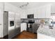 Updated kitchen features stainless steel appliances and white cabinets with hardwood floors at 204 E Murray Ave, Durham, NC 27704