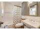 Well-lit bathroom featuring classic white subway tiles and a patterned shower curtain at 206 S Salem St, Apex, NC 27502