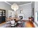 Formal dining room features stylish wallpaper, hardwood floors, and a decorative fireplace at 206 S Salem St, Apex, NC 27502