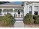 Inviting front porch with decorative columns, planters, and manicured hedges at 206 S Salem St, Apex, NC 27502