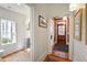 Bright hallway with hardwood floors offering access to a powder room and the home's front entrance at 206 S Salem St, Apex, NC 27502