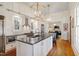 Gourmet kitchen features a large island with seating, custom cabinets and a stainless range at 206 S Salem St, Apex, NC 27502