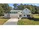Aerial view of white farmhouse with green metal roof, garage, and elevated deck spaces at 220 Epps Clark Rd, Siler City, NC 27344