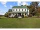 Beautiful two-story home with a green metal roof, covered front porch, and manicured lawn at 220 Epps Clark Rd, Siler City, NC 27344