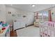 Adorable Bedroom features a crib, changing table, and cozy armchair near a window at 23 Sparkle Ln, Garner, NC 27529