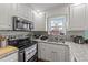 Functional kitchen boasts stainless appliances, granite counters, and stylish backsplash at 23 Sparkle Ln, Garner, NC 27529
