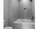 Bathroom features sleek gray tiling and a built-in shelf, offering a minimalist design at 2623 Marchmont St, Raleigh, NC 27608