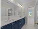 Elegant bathroom with double sinks, a large mirror, and stylish navy blue cabinets at 2623 Marchmont St, Raleigh, NC 27608