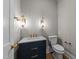 Powder room with dark vanity, marble countertop, gold hardware, and modern lighting at 2623 Marchmont St, Raleigh, NC 27608