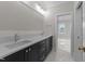Modern bathroom featuring double sink vanity with stylish fixtures, white countertops, and sleek black cabinets at 2623 Marchmont St, Raleigh, NC 27608