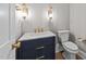Stylish powder room with navy vanity, marble countertop, and gold fixtures at 2623 Marchmont St, Raleigh, NC 27608