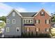 Two-story home showcasing a blend of brick and gray siding, complemented by dark shutters at 2623 Marchmont St, Raleigh, NC 27608