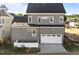 Aerial view of a home with gray siding, a white garage door, and a well-manicured lawn at 2623 Marchmont St, Raleigh, NC 27608