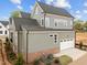 Two-story home features gray siding, a dark roof, attached garage and lush side yard landscaping at 2623 Marchmont St, Raleigh, NC 27608