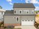 Two-story home with gray siding, dark roof, attached garage and lush landscaping at 2623 Marchmont St, Raleigh, NC 27608