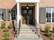 Inviting front entrance with a stylish dark double door, stone steps and elegant columns at 2623 Marchmont St, Raleigh, NC 27608