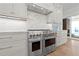Gourmet kitchen featuring a commercial range, custom cabinetry, and modern backsplash at 2623 Marchmont St, Raleigh, NC 27608