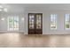 Bright living room featuring hardwood floors, double doors, and abundant natural light at 2623 Marchmont St, Raleigh, NC 27608