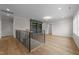 Spacious loft area featuring hardwood floors, custom built-in shelving, and a staircase with black metal railings at 2623 Marchmont St, Raleigh, NC 27608