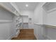 Bright walk-in closet with custom shelving, wooden rods, and modern design elements throughout at 2623 Marchmont St, Raleigh, NC 27608