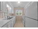 A galley kitchen with white cabinets and appliances, and linoleum flooring at 2821 Edridge Ct # 102, Raleigh, NC 27612