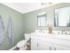 Bathroom offers white cabinets, sage green walls, and a double vanity at 318 Highland Forest Dr, Fuquay Varina, NC 27526