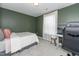Comfortable bedroom featuring modern gray walls, carpet flooring, and a cozy bed near a sunlit window at 318 Highland Forest Dr, Fuquay Varina, NC 27526