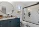 Stylish bathroom featuring a shower with a glass door, blue vanity, and modern fixtures at 3212 Oxford Dr, Durham, NC 27707
