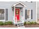 Close-up of a bright red front door with white trim and decorative wreath, complemented by gray siding at 3212 Oxford Dr, Durham, NC 27707