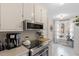 Well-lit kitchen with stainless steel appliances, white cabinets, and backyard views at 3212 Oxford Dr, Durham, NC 27707