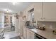 Cozy kitchen featuring white cabinets, stainless steel appliances, and a view to the outside at 3212 Oxford Dr, Durham, NC 27707