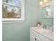A stylish half-bath with a decorative mirror, white vanity, and refreshing green walls at 3304 Glen Currin Dr, Raleigh, NC 27612