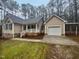 Inviting single story home with attached garage and covered portico, surrounded by mature trees and landscaped grounds at 4050 Brooksdale Dr, Franklinton, NC 27525