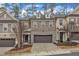Beautiful exterior of a townhome with a two-car garage, stone accents, and landscaped front yard at 410 Bent Tree Ln, Cary, NC 27519