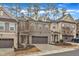 An exterior view of townhomes featuring multi-car garages, brick facades, and manicured lawns at 410 Bent Tree Ln, Cary, NC 27519