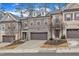 A row of townhomes showcases an attractive exterior with brick, stone accents, and private garages at 410 Bent Tree Ln, Cary, NC 27519