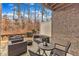 Relaxing covered patio features wicker furniture and a cozy fire pit with wooded view at 410 Bent Tree Ln, Cary, NC 27519