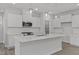 A modern white kitchen featuring an island, stainless steel appliances, and pendant lighting at 44 Fairwinds Drive Dr, Lillington, NC 27546