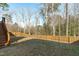 Fully fenced in back yard with green space and staircase to wooden deck at 4940 Heathshire Dr, Raleigh, NC 27616