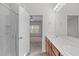 Bathroom featuring double sinks, wood cabinets, and shower with glass door at 4940 Heathshire Dr, Raleigh, NC 27616