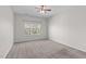 Neutral bedroom featuring carpeted floors, a ceiling fan, and a large window at 4940 Heathshire Dr, Raleigh, NC 27616